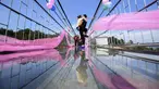 Sepasang pria dan wanita berciuman diatas sebuah jembatan kaca saat mengikuti kontes berciuman di Hari Valentine di Pingjiang, Provinsi Hunan, China (14/2). (STR / AFP)