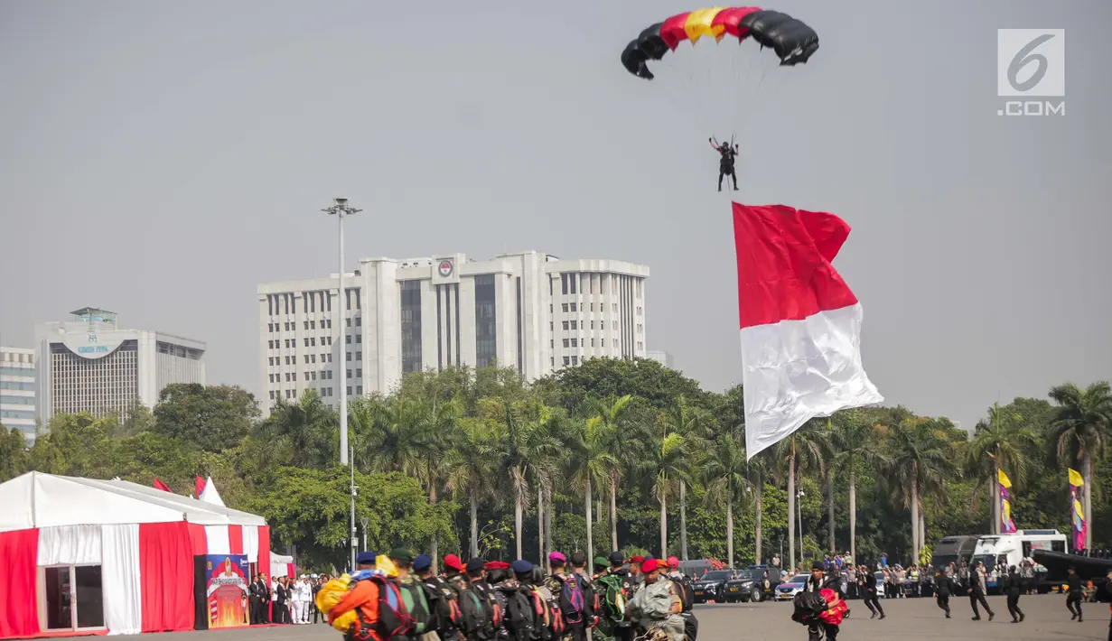 Penerjun payung bersiap mendarat saat tampil dalam perayaan HUT ke-73 Bhayangkara di Monas, Jakarta, Rabu (10/7/2019). Sebanyak 22 penerjun payung dari TNI dan Polri ikut menyemarakkan HUT ke-73 Bhayangkara. (Liputan6.com/Faizal Fanani)