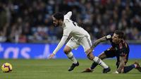 Gelandang Real Madrid, Isco, ditarik kakinya oleh striker Valencia, Santi Mina, pada laga La Liga di Stadion Santiago Bernabeu, Madrid, Sabtu (1/12). Madrid menang 2-0 atas Valencia. (AFP/Oscar Del Pozo)