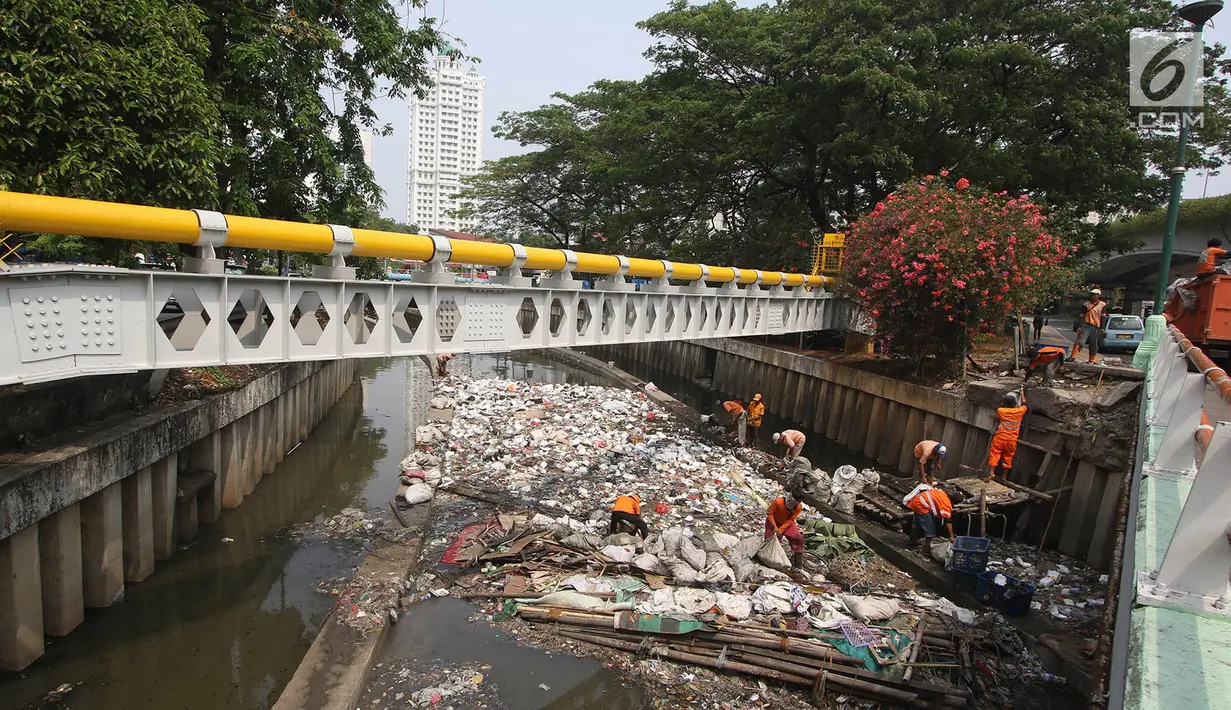 Petugas PPSU mencoba mengurai sampah yang menumpuk di Kali Cideng, Jakarta Pusat, Senin (11/9). Selain penampakannya yang tidak nyaman dipandang, bau yang menyengat juga mengganggu warga yang melintas di kawasan tersebut. (Liputan6.com/Immanuel Antonius)