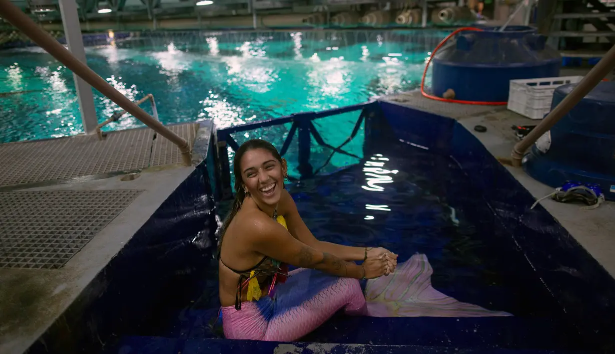 Mahasiswi biologi laut Isabela Cardoso berkostum putri duyung bersiap menyelam di Rio de Janeiro Aquarium, Brasil (14/1). Aksi Isabela tersebut untuk memprotes bahaya pencemaran laut dalam kehidupan laut di Rio de Janeiro. (AFP Photo/Mauro Pimentel)