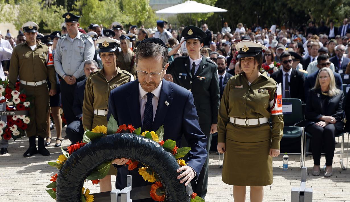 <p>Presiden Israel Isaac Herzog memberikan penghormatan saat upacara peletakan karangan bunga menandai Hari Peringatan Holocaust di Warsaw Ghetto Square, Yad Vashem, Yerusalem, Israel, 28 April 2022. (Amir Cohen/Pool Photo via AP)</p>