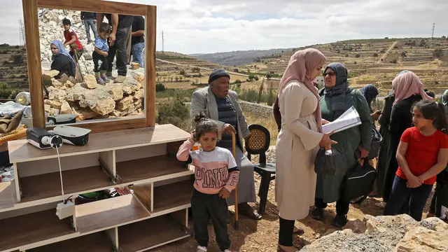 Warga Palestina pasrah saat pasukan Israel menghancurkan bangunan mereka di daerah Wadi Muhaisen, utara kota Hebron. (AFP)