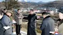 Foto tidak bertanggal yang disediakan pada 16 November 2021 ini memperlihatkan pemimpin Korea Utara Kim Jong-un (tengah) memeriksa lokasi pembangunan proyek pengembangan Kota Samjiyon di Provinsi Ryanggang, Korea Utara. (Korean Central News Agency/Korea News Service via AP)