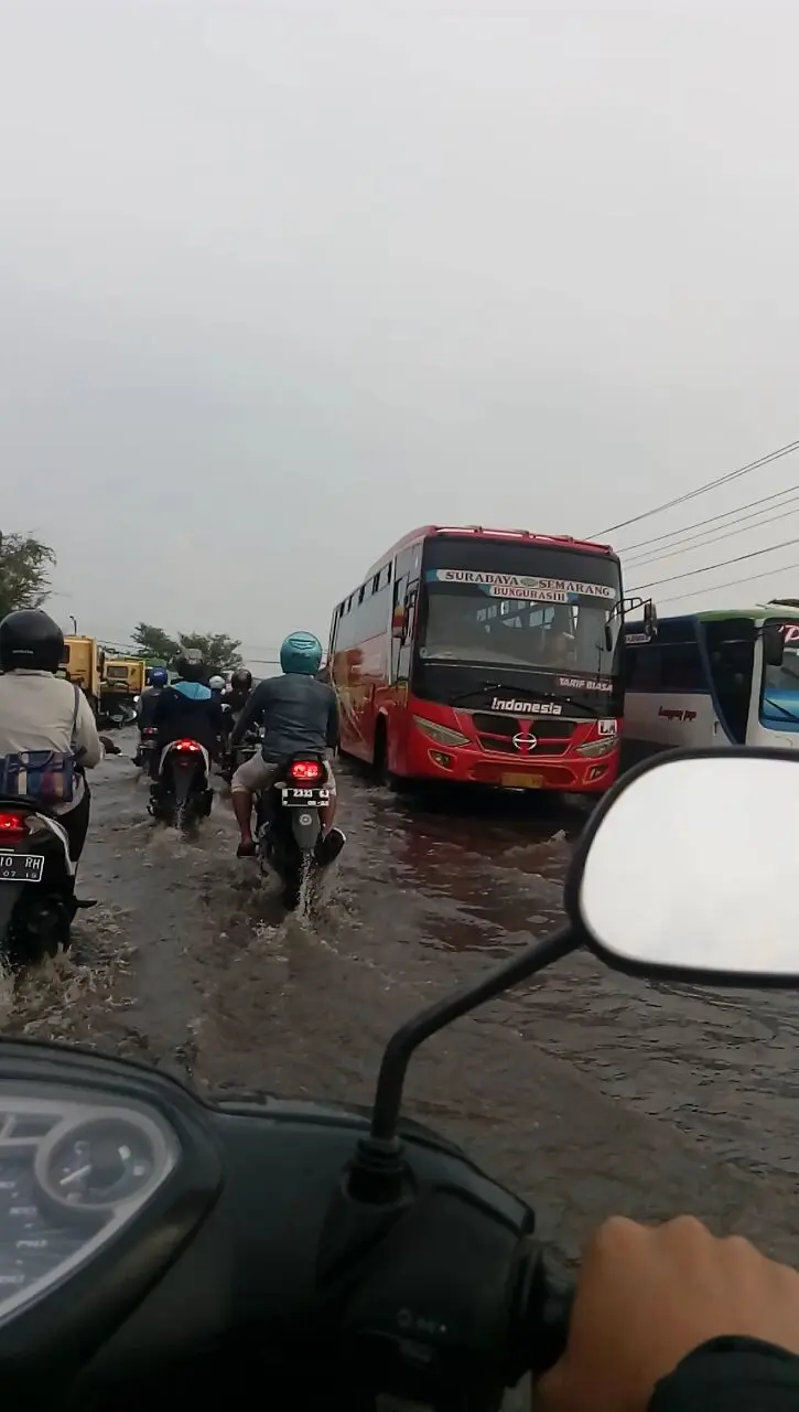 Pengguna sepeda motor sering nekad menerobos banjir dan kemacetan agar mesin terhindar dari siraman air akibat ombak yang ditimbulkan lindasan roda mobil. (foto : /edhie prayitno ige)