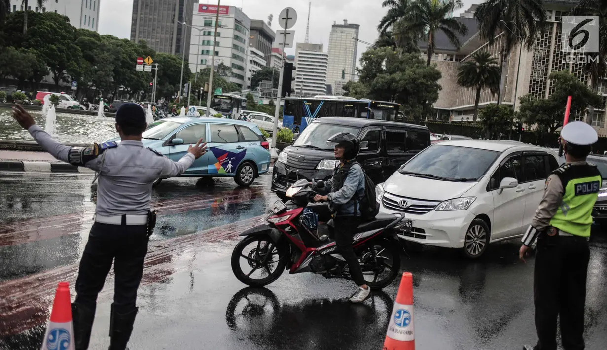 Polisi dan petugas Dishub mengalihakan arus lalu lintas terkait Malam Munajat 212 di Medan Merdeka Barat dan Utara, Jakarta, Kamis (21/2). Masyarakat yang akan melintasi kawasan Monas diharapkan mencari jalur alternatif. (Liputan6.com/Faizal Fanani)