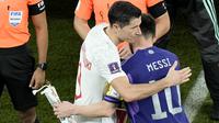 Pemain Polandia, Robert Lewandowski (kiri) dan pemain Argentina, Lionel Messi berpelukan sebelum mulainya laga matchday ketiga Grup C Piala Dunia 2022 di Stadion 974, Kamsi (01/12/2022). (AP/Hassan Ammar)