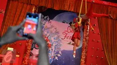 Pengunjung mengambil gambar dari atraksi Aero Silk-oriental Acrobatic di salah satu pusat perbelanjaan di Jakarta, Jumat (29/1). Dalam rangka Imlek 2567, sejumlah pusat perbelanjaan menggelar berbagai atraksi budaya Tionghoa. (Liputan6.com/Gempur M Surya)
