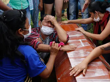 Sejumlah wanita menangis di samping peti mati dalam upacara pemakaman korban banjir dan tanah longsor di Mocoa, Kolombia, (3/4). Musibah ini memakan korban jiwa hingga ratusan orang dan menghancurkan seluruh lingkungan. (AP Photo / Fernando Vergara)