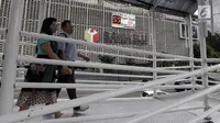 Pejalan kaki melintas di jembatan penyeberangan orang (JPO) dengan latar belakang layar hitung mundur Pemilu 2019 di Gedung Bawaslu, Jakarta, Kamis (21/2). Layar dipasang untuk mengajak masyarakat ikut serta dalam Pemilu 2019. (Merdeka.com/Iqbal Nugroho)