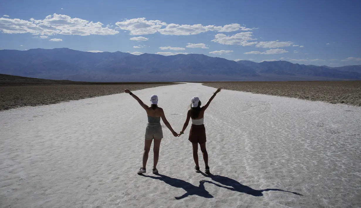 Orang-orang berpose untuk foto di dataran garam di Badwater Basin, di Taman Nasional Death Valley, Taman Nasional Death Valley, California, Kamis (1/9/2022). Menurut Organisasi Meteorologi Dunia, tercatat suhu terpanas di kawasan ini pernah mencapai 45 derajat Celcius, yang terjadi pada 22 April 2012 silam. (AP Photo/John Locher)