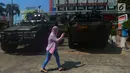 Pejalan kaki melintas di depan kendaraan lapis baja TNI di pertokoan Glodok, Jakarta, Jumat (11/5). Aksi Bela Palestina tersebut sebagai protes atas pemindahan Kedubes AS dari Tel Aviv di Israel ke kota Yerusalem di Palestina. (Merdeka.com/Imam Buhori)