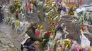 Seorang pelayat meninggalkan karangan bunga di sepanjang pagar yang dipasang di sekitar tempat parkir tempat penembakan massal terjadi di toko kelontong King Soopers Selasa, 23 Maret 2021, di Boulder, Colo. (Foto AP / David Zalubowski)