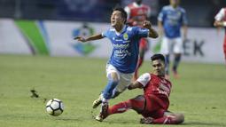 Gelandang Persib Bandung, Oh Inkyun, terjatuh saat berebut bola dengan pemain Arema FC pada laga Liga 1 di Stadion GBLA, Jawa Barat, Kamis (13/9/2018). Persib menang 2-0 atas Arema FC. (Bola.com/M Iqbal Ichsan)