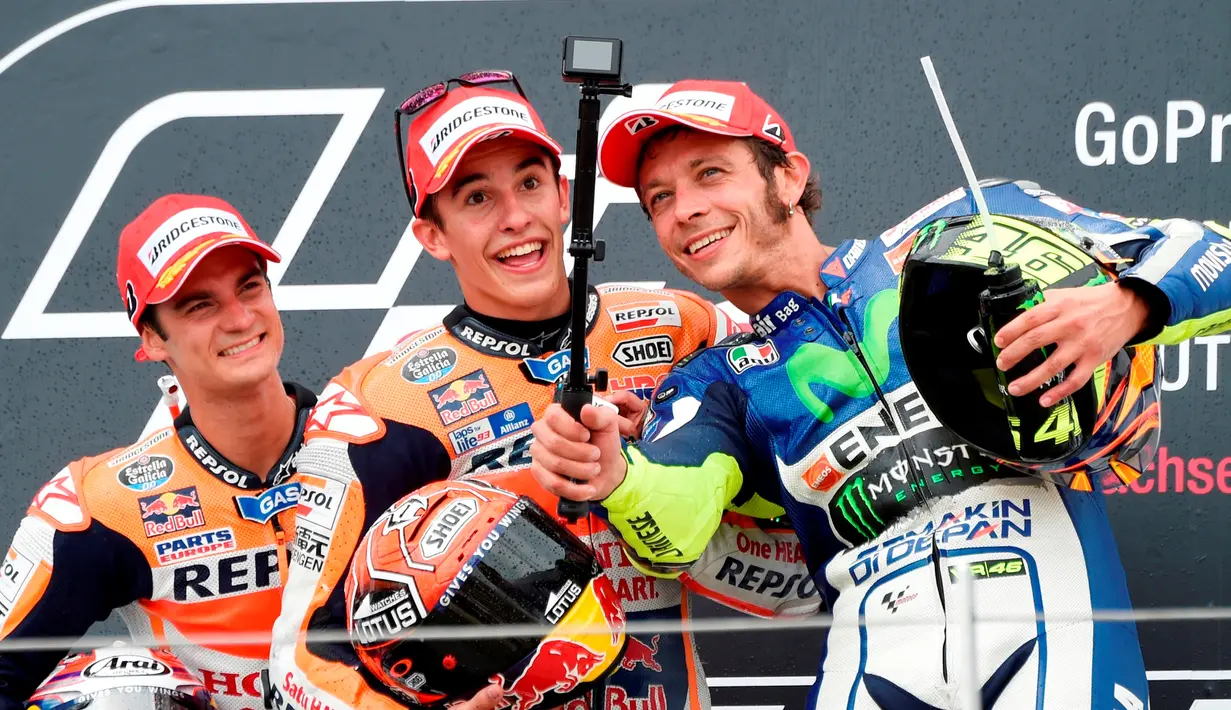 Selfie Valentino Rossi bersama Marc Marquez dan Dani Pedrosa di podium MotoGP Jerman. (AP Photo/Jens Meyer)