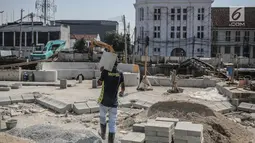 Pekerja membawa batu saat pengerjaan proyek revitalisasi kawasan Kota Tua di Jakarta, Jumat (15/9). Rencananya proyek ini akan diresmikan oleh Gubernur DKI Jakarrta Djarot Saiful Hidayat pada 5 Oktober. (Liputan6.com/Faizal Fanani)