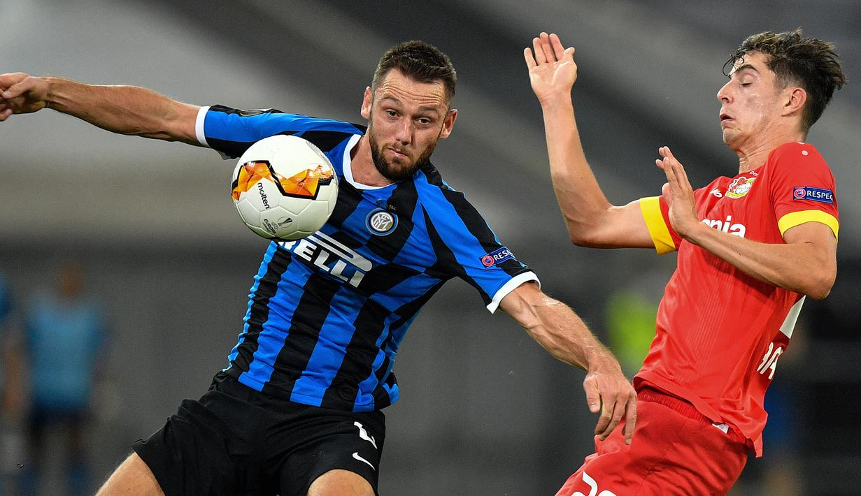Bek Inter Milan, Stefan de Vrij, berebut bola dengan gelandang Bayer Leverkusen, Kai Havertz, pada perempat final Liga Europa 2019/2020 di Merkur Spiel-Arena, Jerman, Selasa (11/8/2020) dini hari WIB. Inter Milan menang 2-1 atas Bayer Leverkusen. (AFP/Martin Meissner/pool)