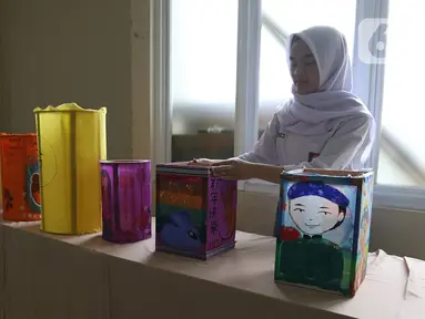 Seorang siswi merapikan lukisan bernuansa imlek di SMA Negri 39 Jakarta, Selasa (21/1/2020). Kerajinan lukisan tersebut dibuat oleh siswa untuk menyambut hari imlek 2571 yang jatuh pada Sabtu (25/1) 2020. (Liputan6.com/Herman Zakharia)