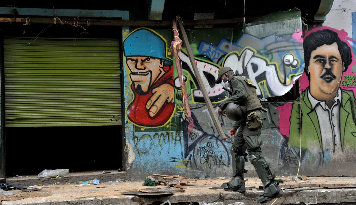 Polisi saat menggerebek kampung narkoba dan prostitusi The Bronx di Bogota, Kolombia (1/6). The Bronx terkenal sebagai lautan penderitaan, kemiskinan dan kecanduan, menjebak ribuan orang yang datang dan sulit untuk keluar. (AFP PHOTO/Guillermo LEGARIA)