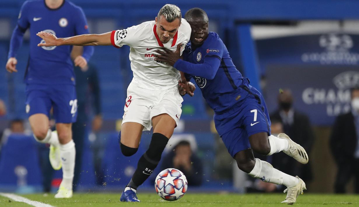 Gelandang Chelsea, N'Golo Kante, berebut bola dengan Gelandang Sevilla, Joan Jordan Moreno, pada laga Grup E Liga Champions 2020/2021 di Stamford Bridge, Rabu (21/10/2020) dini hari WIB. Chelsea bermain imbang 0-0 atas Sevilla. (AFP/Alastair Grant/pool)