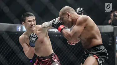 Petarung China, Peng Xue Wen (kiri) melakukan pukulan ke petarung Filipina, Rene Catalan (kanan) saat berlaga pada One Championship di Jakarta, Sabtu (20/1). Petarung Rene Catalan menang atas Peng Xue Wen. (Liputan6.com/Faizal Fanani)