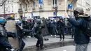 Pengunjuk rasa berhadapan dengan polisi anti huru hara saat unjuk rasa di ibukota Prancis, Paris, Kamis (31/3). Mereka menolak rancangan undang-undang sosialis pemerintah Prancis yang dinilai merugikan pekerja. (Thomas SAMSON/AFP)