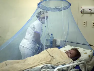 Perawat Liz Cabanas merawat seorang pria yang terinfeksi chikungunya di Rumah Sakit Clinicas di San Lorenzo, Paraguay, Jumat (3/3/2023). Pengawasan Kesehatan menyatakan bahwa dalam tiga minggu terakhir lebih dari 1200 kasus penyakit yang ditularkan oleh nyamuk telah terjadi. telah dilaporkan. (AP Photo/Jorge Saenz)