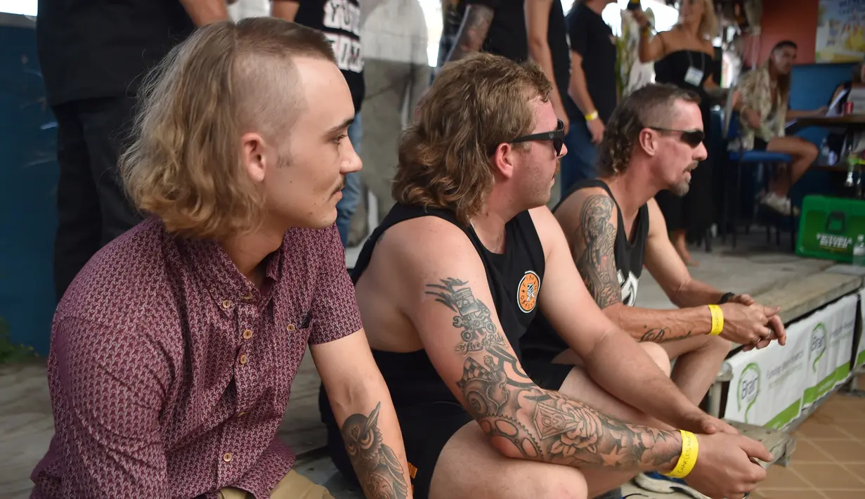 Para peserta menunggu penilaian gaya rambutnya dalam Mulletfest 2018 di Kota Kurri Kurri, Sydney, Australia, Sabtu (24/2). Mullet memiliki ciri khas potongan pendek di bagian depan, bervolume, serta panjang di samping dan belakang. (PETER PARKS/AFP)