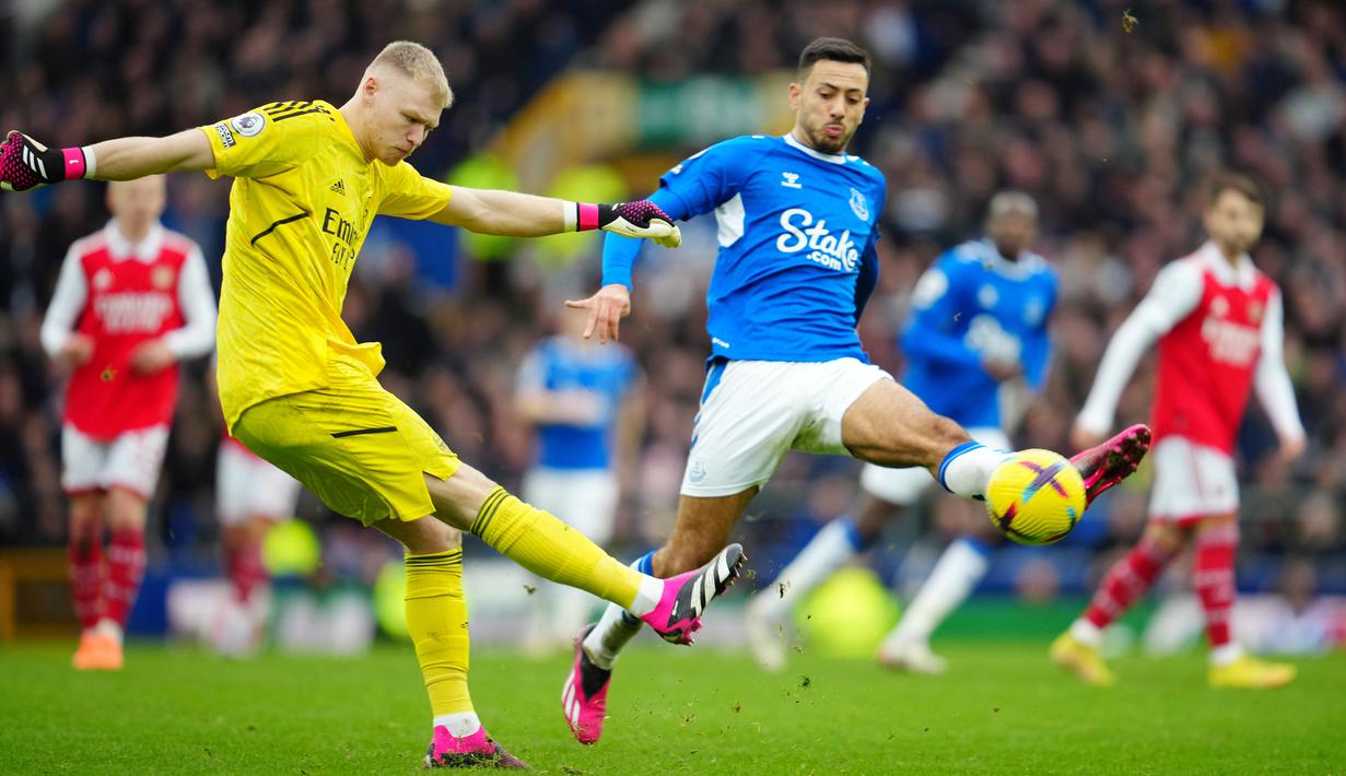 Kiper Arsenal Aaron Ramsdale menendang bola di depan pemain Everton Dwight McNeil pada pertandingan sepak bola Liga Inggris di Goodison Park, Liverpool, Inggris, 4 Februari 2023. Everton mengalahkan Arsenal dengan skor 1-0. (AP Photo/Jon Super)