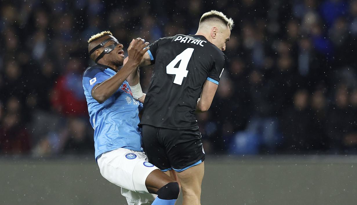 Pemain Napoli, Victor Osimhen diadang pemain Lazio, Patric, pada laga Liga Italia di Stadion Diego Armando Maradona, Sabtu (4/3/2023). Napoli menelan kekalahan saat menjamu Lazio pada pekan ke-25 Serie A 2022/2023. 
(Alessandro Garofalo/LaPresse via AP)