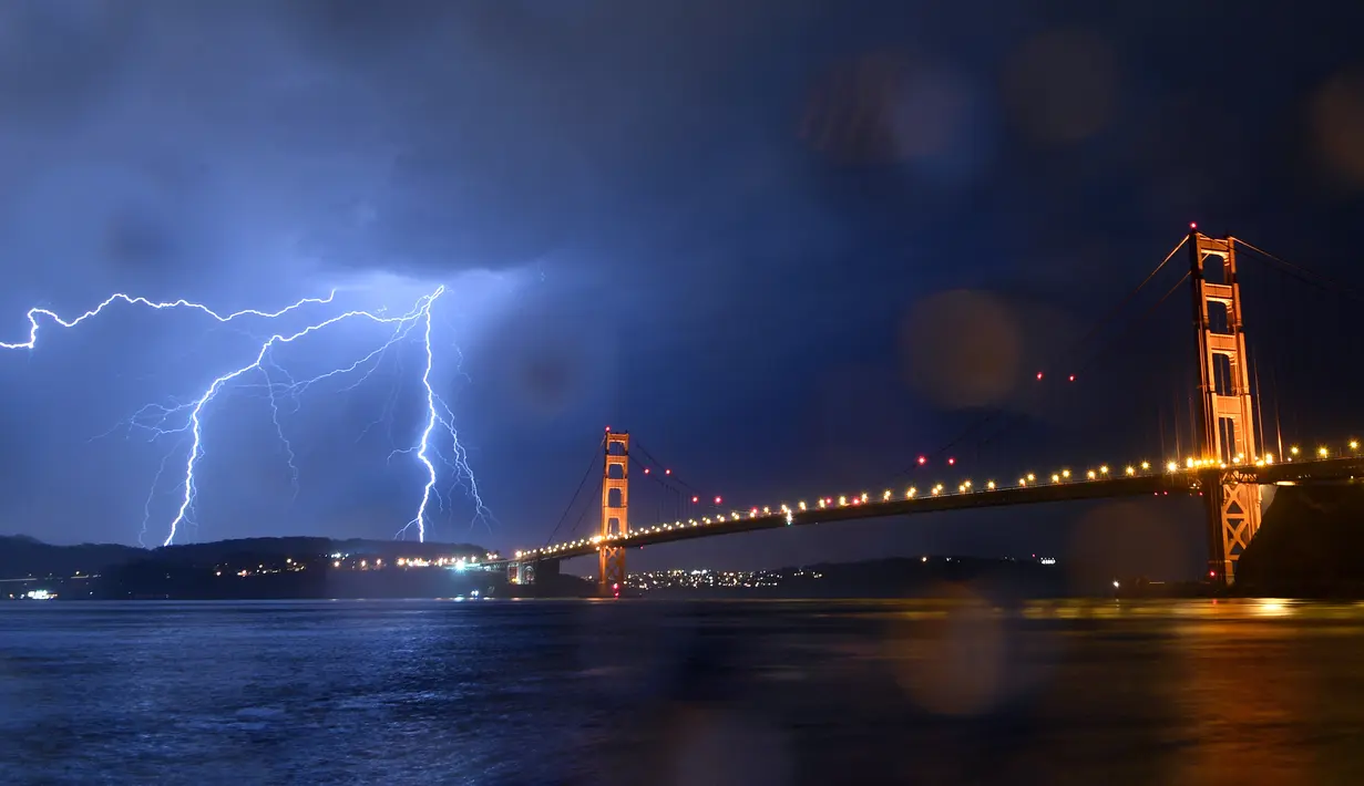 Suasana jembatan Golden Gate saat terjadi sambaran petir, San Francisco, California, AS (11/9). Petir mengeluarkan suara yang menggelegar yang disebut guruh. (AFP Photo/Josh Edelson)