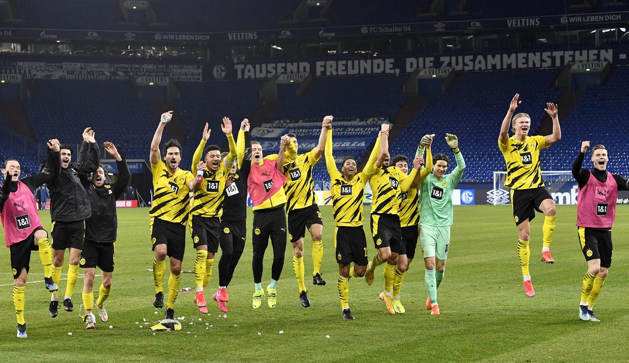 Para pemain Borussia Dortmund merayakan kemenangan 4-0 atas Schalke usai berakhirnya laga lanjutan Liga Jerman 2020/21 pekan ke-22 di Veltins Arena, Sabtu (20/2/2021). (AP/Martin Meissner/Pool)