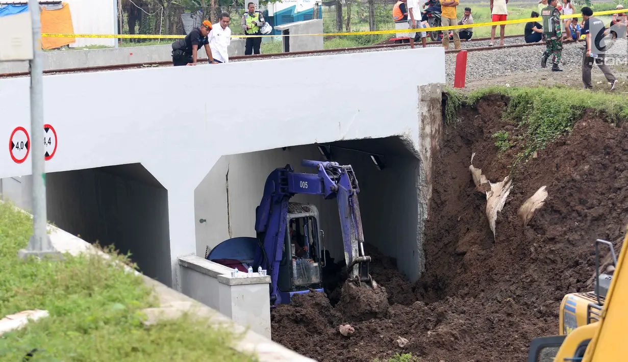 Alat berat membersihkan tanah longsor di Underpass Perimeter, Bandara Soetta, Tangerang, Banten, Selasa (6/2). Enam alat berat dikerahkam untuk proses tersebut. (Liputan6.com/Angga Yuniar)