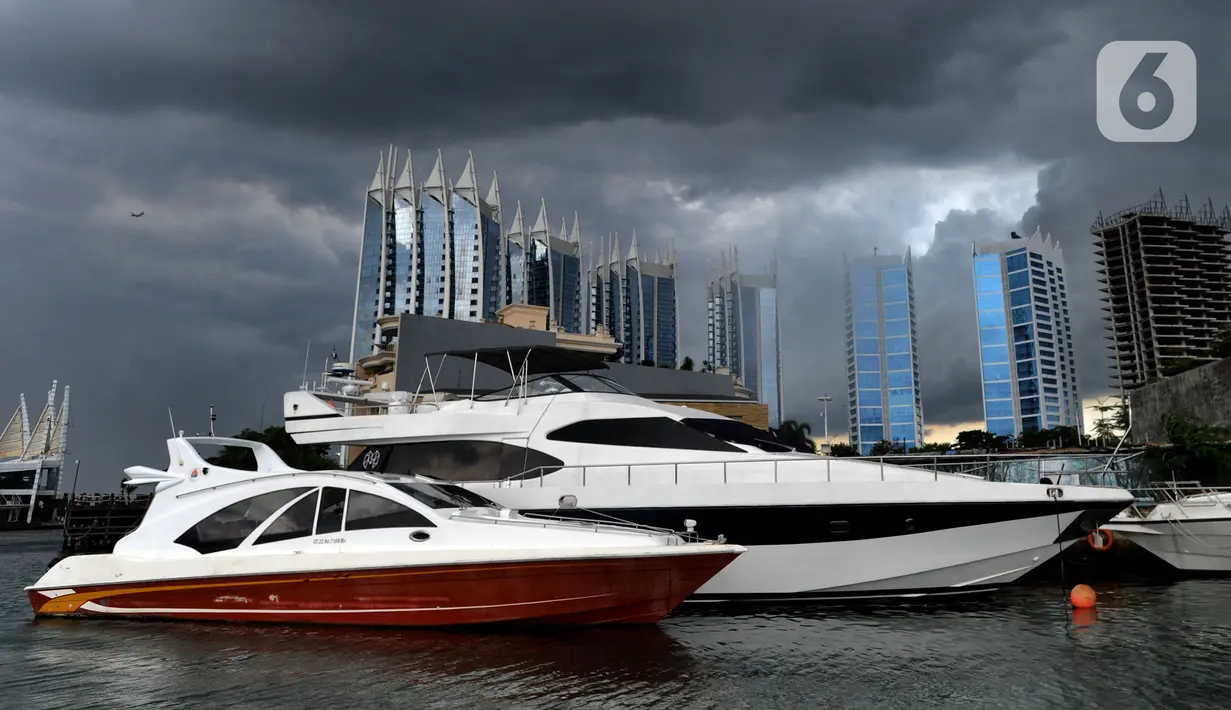 Kapal-kapal bersandar saat awan cumulonimbus menyelimuti perairan Teluk Jakarta, Minggu (10/1/2021). Sejak beberapa hari terakhir, perairan Teluk Jakarta diselimuti cuaca ekstrem yang berbahaya bagi pelayaran dan penerbangan. (merdeka.com/Arie Basuki)