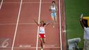 Atlet putri Indonesia, Triyaningsih mengangkat tangan usai memastikan finis pertama di nomor 10.000 M di National Stadium Singapura, Kamis (11/6/2015). Triyaningsih mencatatkan waktu 33 menit 44,53 detik. (Liputan6.com/Helmi Fithriansyah)