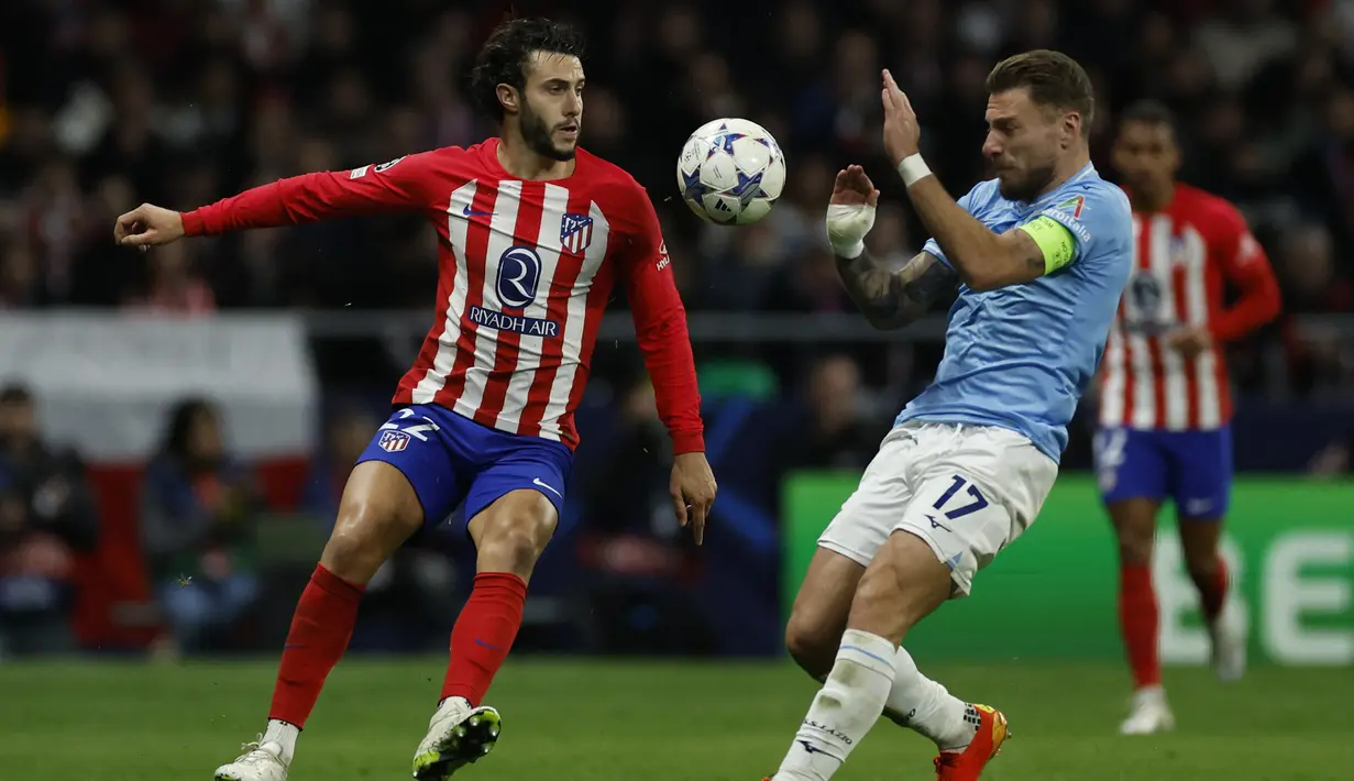 Bek Atletico Madrid #22 Mario Hermoso berebut bola dengan penyerang Lazio #17 Ciro Immobile pada matchday 6 Grup E Liga Champions 2023/2024 di Metropolitano Stadium, Kamis (14/12/2023) dini hari WIB. (OSCAR DEL POZO / AFP)
