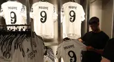 Seorang pria memegang jersey pemain sepak bola Prancis, Kylian Mbappe yang baru saja diluncurkan di toko resmi Real Madrid di stadion Santiago Bernabeu, Madrid, pada 11 Juli 2024. (Pierre-Philippe MARCOU/AFP)