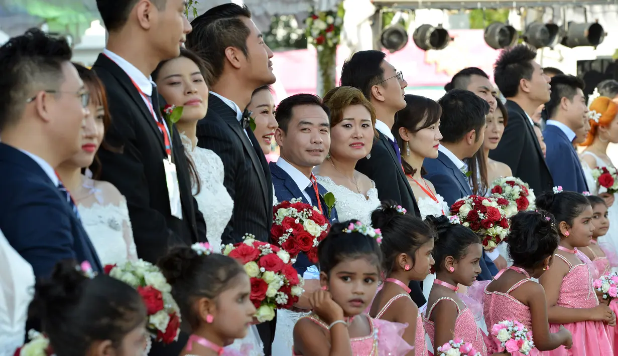 Sejumlah pasangan pengantin asal Tiongkok mengikuti upacara pernikahan massal di Kolombo, Sri Lanka (17/12). Acara nikah massal ini diharapkan dapat meningkatkan hubungan antara Sri Lanka dan Tiongkok. (AFP Photo/Ishara S. Kodikara)