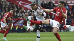 Pemain Manchester United, Antony (tengah) berebut bola dengan pemain Nottingham Forest, Remo Freuler saat laga pekan ke-31 Liga Inggris 2022/2023 di City Ground, Nottingham, Senin (17/04/2023) dini hari WIB. Setan Merah berhasil menang dengan skor 2-0. (AP Photo/Rui Vieira)