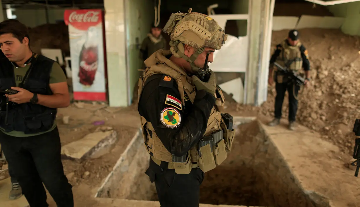Sejumlah anggota pasukan khusus Irak berjaga di dekat terowongan yang digunakan oleh militan ISIS di dalam sebuah restoran di Bazwaya, Mosul, Irak (27/10). Sejumlah terowongan yang digunakan ISIS telah ditemukan di sekitar Mosul. (REUTERS/Zohra Bensemra)