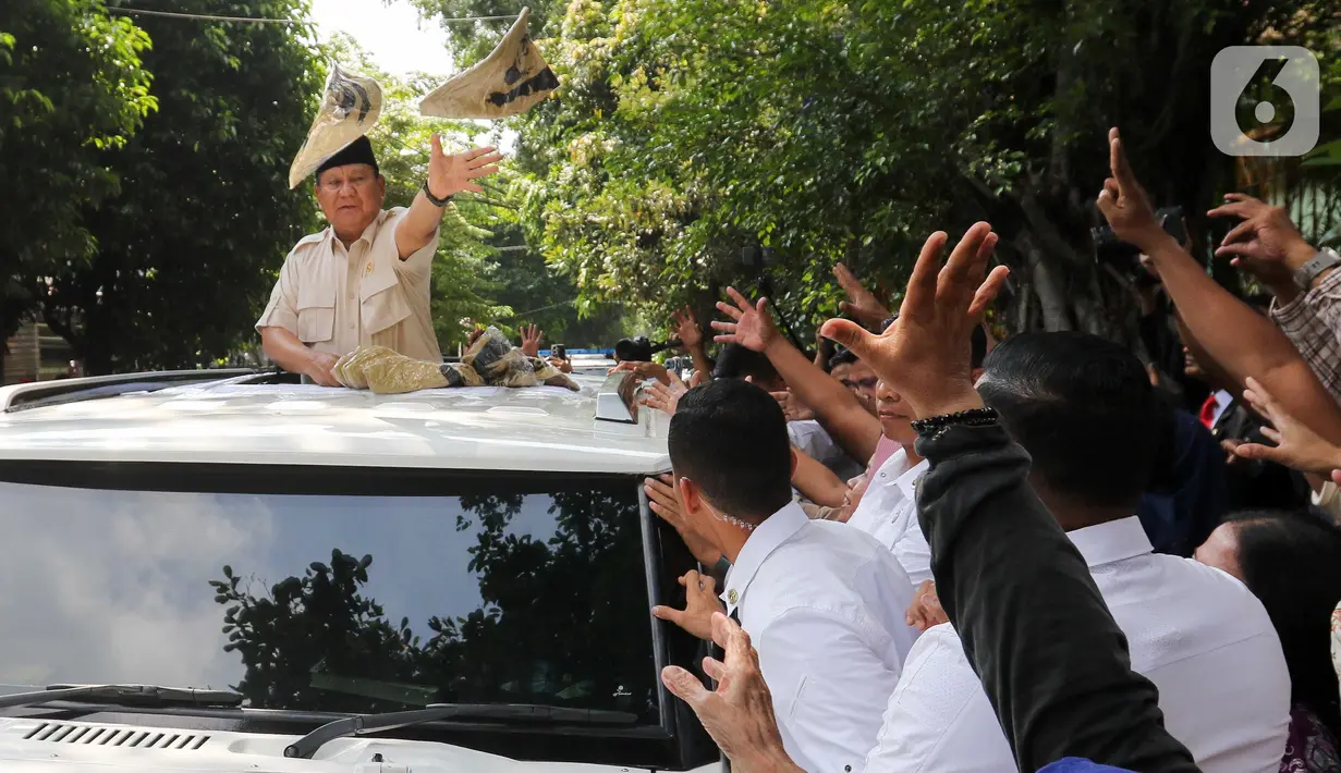 Presiden Republik Indonesia Prabowo Subianto menyapa warga sekaligus membagikan kaos seusai kunjungan dari Sekolah Dasar Negeri (SDN) Jati 03, Jakarta, Rabu (7/5/2025). (Liputan6.com/Herman Zakharia)