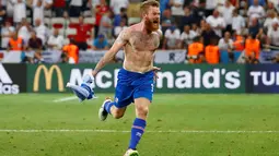 Kapten timnas Islandia, Aron Gunnarsson merayakan kemenangan Islandia atas Inggris dengan cara melepas jerseynya, Selasa (28/6) dini hari. Islandia membuat kejutan besar dengan menyingkirkan Inggris dari Piala Eropa 2016. (REUTERS/Michael Dalder)