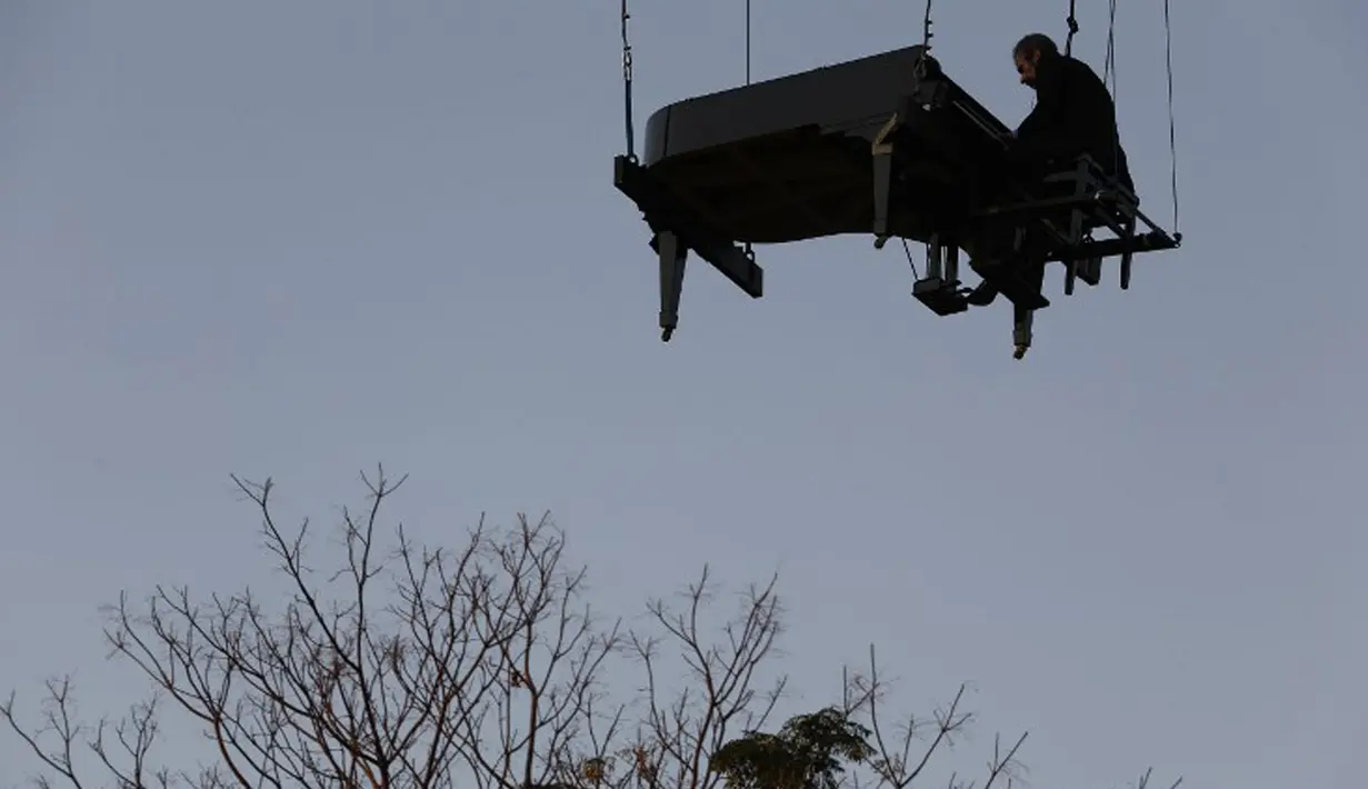 Aksi Pianis Ricardo de Castro Monteiro saat bermain piano sambil tergantung di udara selama Virada Cultural di Brasil (22/6/2015). Virada Cultural merupakan acara budaya 24 jam tanpa gangguan dengan berbagai cara unik.  (AFP PHOTO/Miguel Schincariol)
