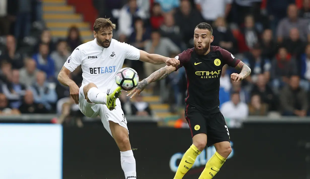 Pemain Swansea City, Fernando Llorente (kiri) berusaha melewati pemain Manchester City  Nicolas Otamendi (kanan) pada lanjutan Premier League di Stadion Liberty, Swansea, Sabtu (24/9/2016). (AFP/Adrian Dennis)