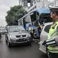 Petugas kepolisian menilang pengendara mobil yang melanggar aturan ganjil genap di Jalan MT Haryono, Jakarta, Kamis (28/10/2021). Para pelanggar sistem ganjil genap dikenakan sanksi tilang berupa denda maksimal Rp500 ribu. (merdeka.com/Iqbal S Nugroho)