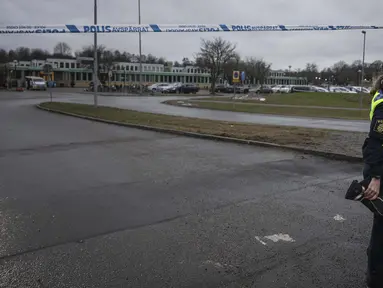 Seorang petugas mengangkat garis penjagaan polisi di luar pusat pendidikan orang dewasa Campus Risbergska di Orebro, Swedia, pada 5 Februari 2025. (Jonathan NACKSTRAND/AFP)