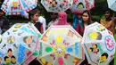 Siswa melukis payung dengan tema ‘Populasi Dunia’ di Allahabad pada 11 Juli 2013. Sebuah penelitian baru dari PBB memprediksi bahwa India akan melampaui China sebagai negara dengan penduduk terbanyak pada tahun 2022. (AFP PHOTO/SANJAY KANOJIA)