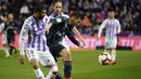 Gelandang Real Madrid, Daniel Ceballos berusaha menguasai bola dari kawalan bek Real Valladolid, Joaquin selama pertandingan lanjutan La Liga Spanyol di stadion Jose Zorrilla,Valladolid (10/3). Madrid menang 4-1 atas Valladolid. (AFP Photo/Cesar Manso)