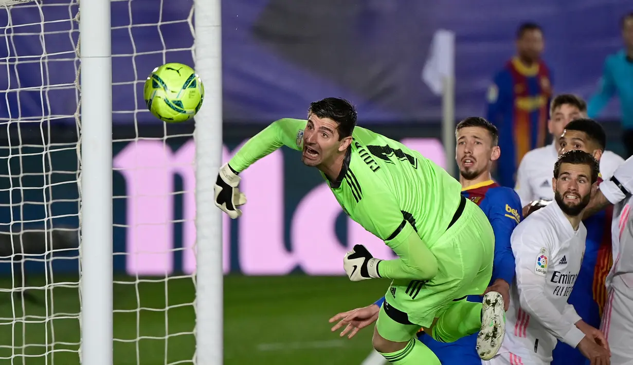 Kiper Real Madrid, Thibaut Courtois menatap bola yang masih melebar dari gawangnya saat melawan Barcelona dalam laga lanjutan Liga Spanyol 2020/2021 pekan ke-30 di Alfredo di Stefano Stadium, Madrid, Sabtu (10/4/2021). Real Madrid menang 2-1 atas Barcelona. (AFP/Javier Soriano)