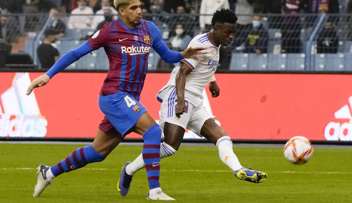Real Madrid berhasil memimpin kedudukan pada menit ke-25. Berawal dari umpan daerah yang dikirim Karim Benzema, Vinicius yang berlari di sisi kiri tak mampu dihentikan oleh Ronald Araujo dan berhasil melepaskan tembakan keras. (AP/Hassan Ammar)